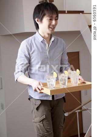 トレーでお酒の入ったグラスを運ぶ男性 6560591