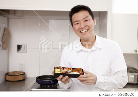 詰めた弁当箱を持つ男性 6560620