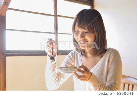 料理を食べる若い女性 6560641