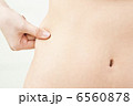 ウエストを摘んでいる女性の手元 6560878