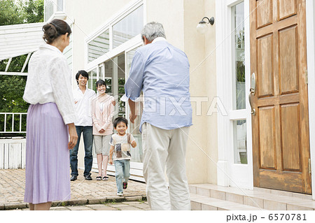 祖父母に駆け寄る孫息子の写真素材