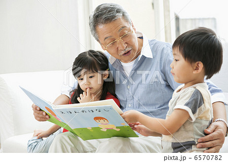 リビングで絵本を読む祖父と孫たち リビングで絵本を読む祖父と孫たち 6570782