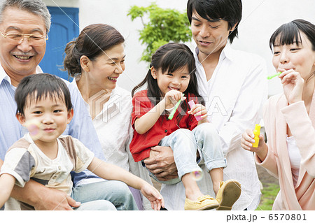 庭でシャボン玉をして遊ぶ三世代家族 6570801