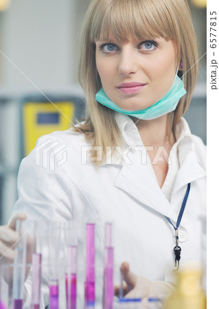 female researcher holding up a test tube in lab 6577815