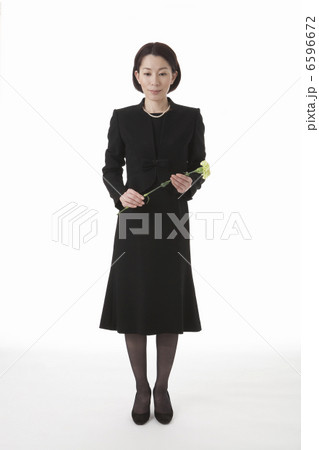 一輪の花を持って立つ喪服姿の女性 6596672