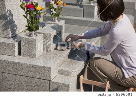 お墓に線香をあげる女性 お墓に線香をあげる女性 6596691