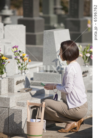 お墓に線香をあげる女性 6596762