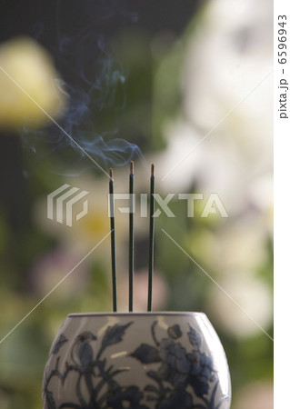 香炉で焚かれた三本の線香と花 6596943