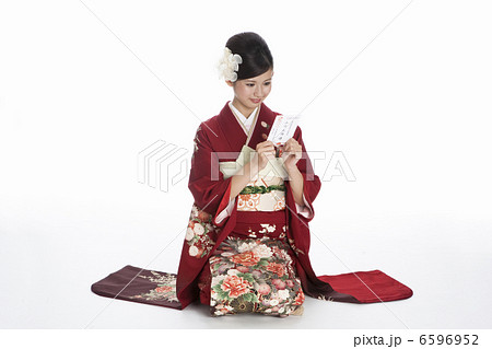 年賀状を見る振袖姿の若い女性 年賀状を見る振袖姿の若い女性 6596952