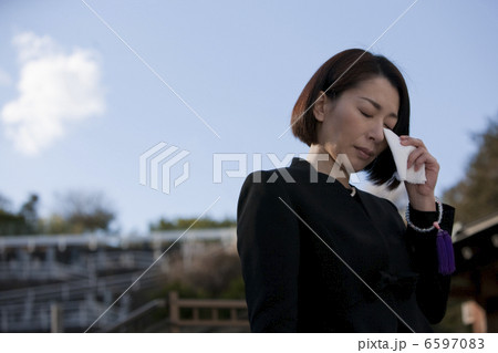 ハンカチで涙を拭う喪服姿の女性 6597083