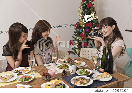 クリスマスパーティーで写真を撮る女性三人 6597104