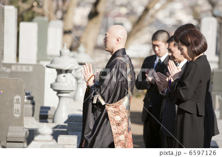 お墓の前で手を合わせる僧侶と喪服姿の遺族 お墓の前で手を合わせる僧侶と喪服姿の遺族 6597126