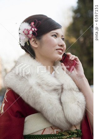 携帯電話を持つ振袖姿の若い女性 6597151