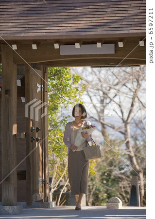 山門に立ち花を持つ女性 6597211