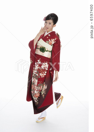 口元に手を当てる振袖姿の若い女性 6597400