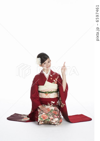 正座で上を指差す振袖姿の若い女性 6597461