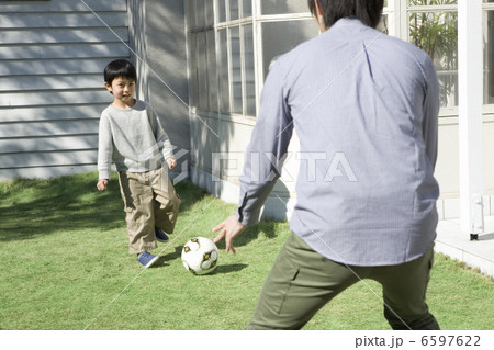 庭でサッカーをする父と息子 6597622