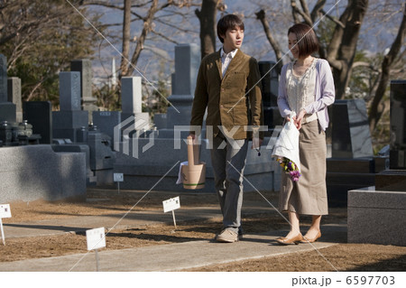 花と水桶を持ち墓地を歩く夫婦 6597703