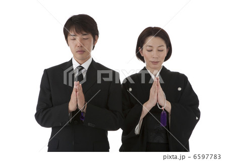数珠を持って合掌する喪服姿の夫婦 正面 6597783