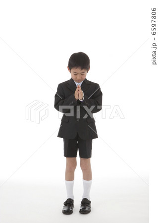 数珠を持って合掌する喪服姿の少年 正面 6597806