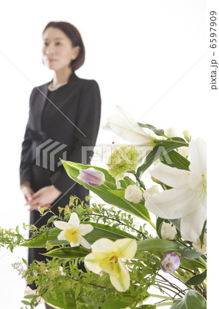 喪服姿の女性と祭壇の花 6597909