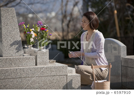 お墓に線香をあげる女性 お墓に線香をあげる女性 6597910