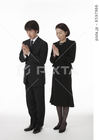 目を閉じ合掌する喪服姿の夫婦 斜め 6597966