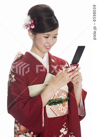 携帯電話を持つ振袖姿の若い女性 携帯電話を持つ振袖姿の若い女性 6598039