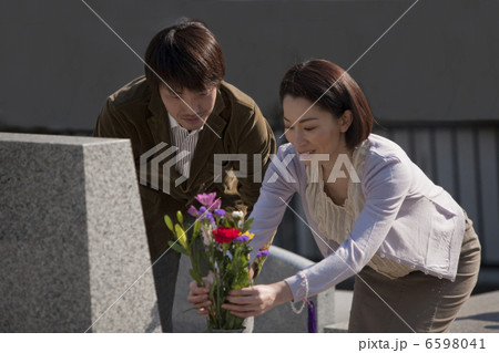 お墓に花を供える夫婦 6598041