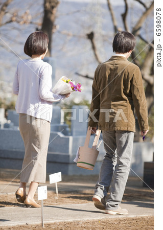 花と水桶を持ち墓地を歩く夫婦の後姿 花と水桶を持ち墓地を歩く夫婦の後姿 6598078
