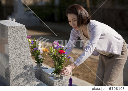 お墓に花を供える女性 6598103
