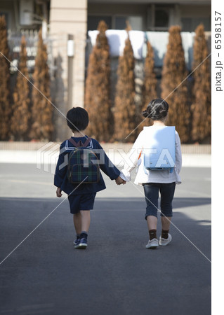 道を歩く男の子と女の子の後ろ姿 6598157