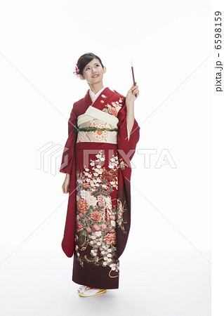 筆を持つ振袖姿の若い女性 6598159