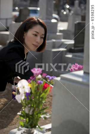 お墓に花を供える喪服姿の女性 お墓に花を供える喪服姿の女性 6598295