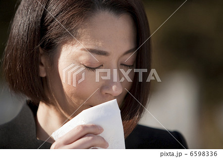 ハンカチで涙を拭う喪服姿の女性 6598336