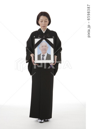 遺影を持って立つ喪服姿の女性 正面 6598387