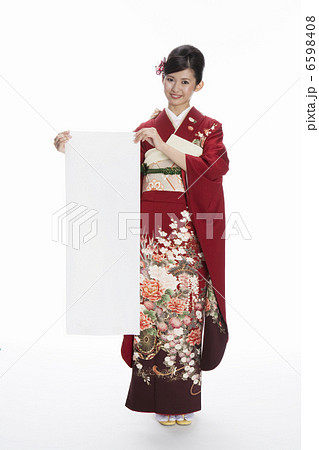 書き初め用紙を持つ振袖姿の若い女性 6598408