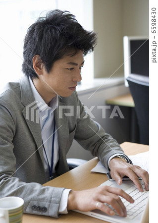オフィスでノートパソコンで作業をする男性 6598430