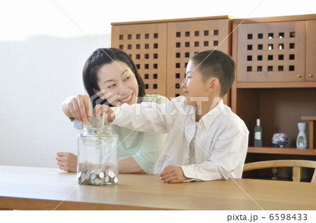 紙幣を貯金する男の子と母親 6598433