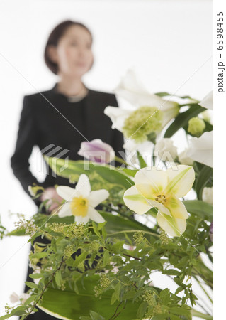 喪服姿の女性と祭壇の花 6598455