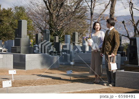 花と水桶を持ち墓地を歩く夫婦 6598491