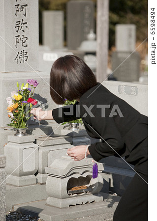 お墓に花を供える喪服姿の女性の後姿 お墓に花を供える喪服姿の女性の後姿 6598494