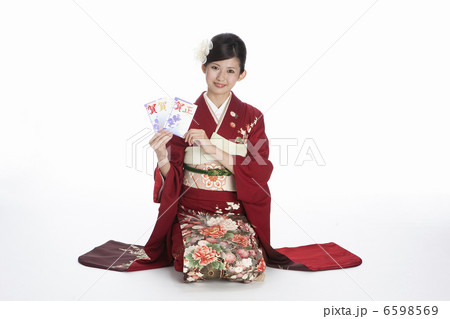 年賀状を持つ振袖姿の若い女性 6598569