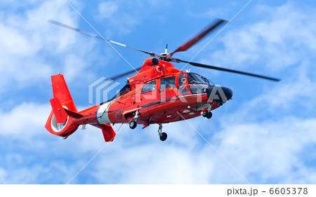 Red rescue helicopter moving in blue sky 6605378