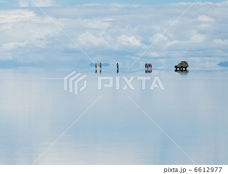 silhouettes of travellers, reflecting in the water 6612977