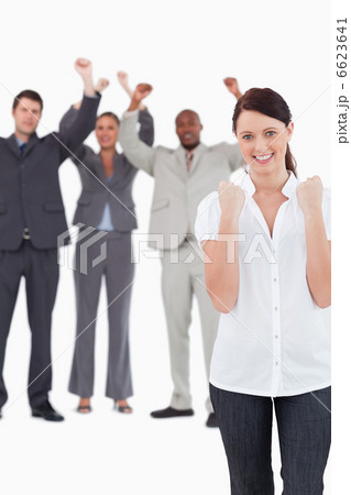 Successful businesswoman with cheering colleagues behind her Successful businesswoman with cheering colleagues behind her 6623641