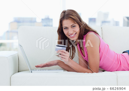 Young woman holding a credit card while showing a great smile 6626904