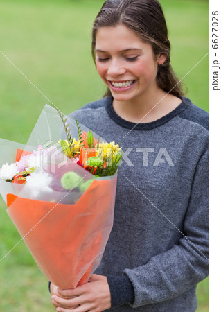 Smiling teenage receiving a bunch of flowers Smiling teenage receiving a bunch of flowers 6627028