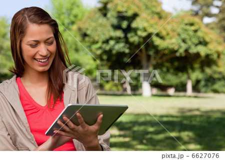 Young woman smiling enthusiastically while using a tablet 6627076