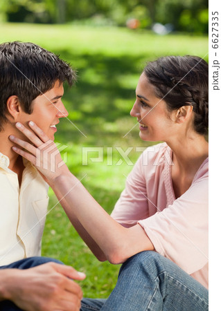 Woman embracing her friends face with her hands 6627335